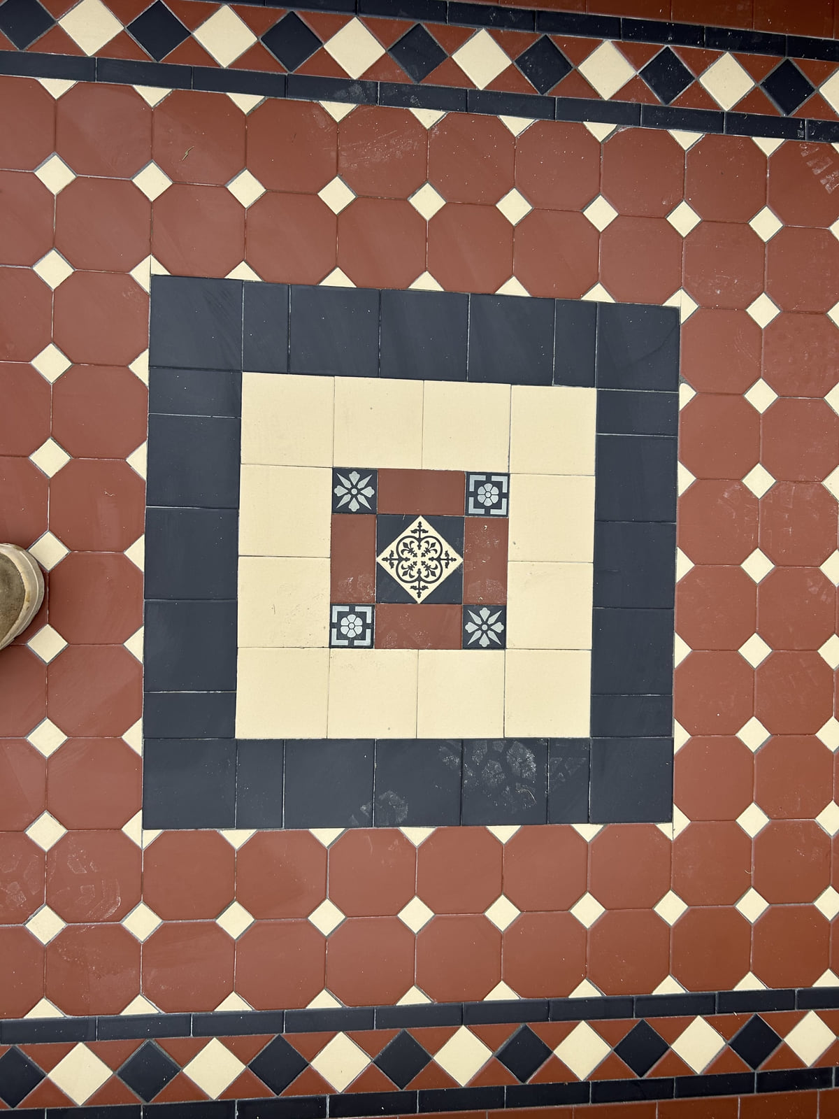 Close-up of an encaustic centre panel with a Norwood diamond border in a brick red Octagon and Dot path, Armidale