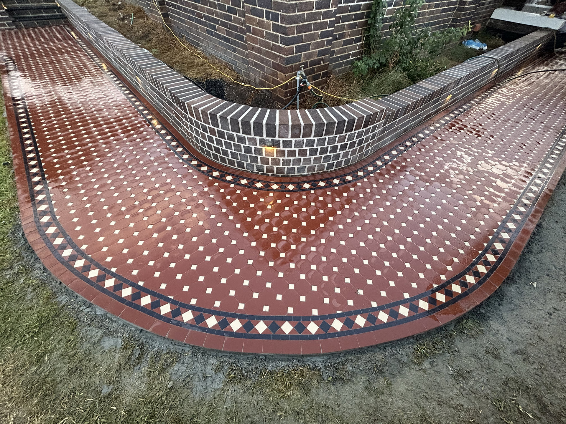 Norwood diamond border following a curved brick wall on a red Octagon and Dot path, Armidale