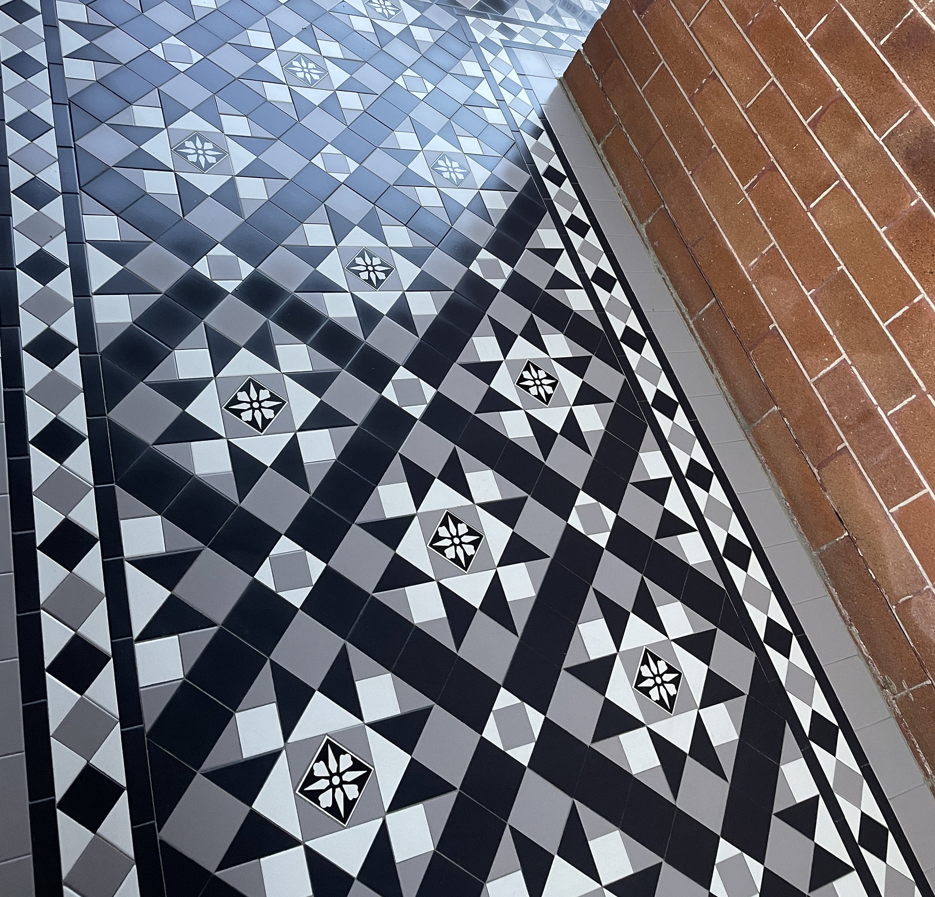 Corner of a diagonal black and white Fitzroy verandah with tiles still wet, Kogarah