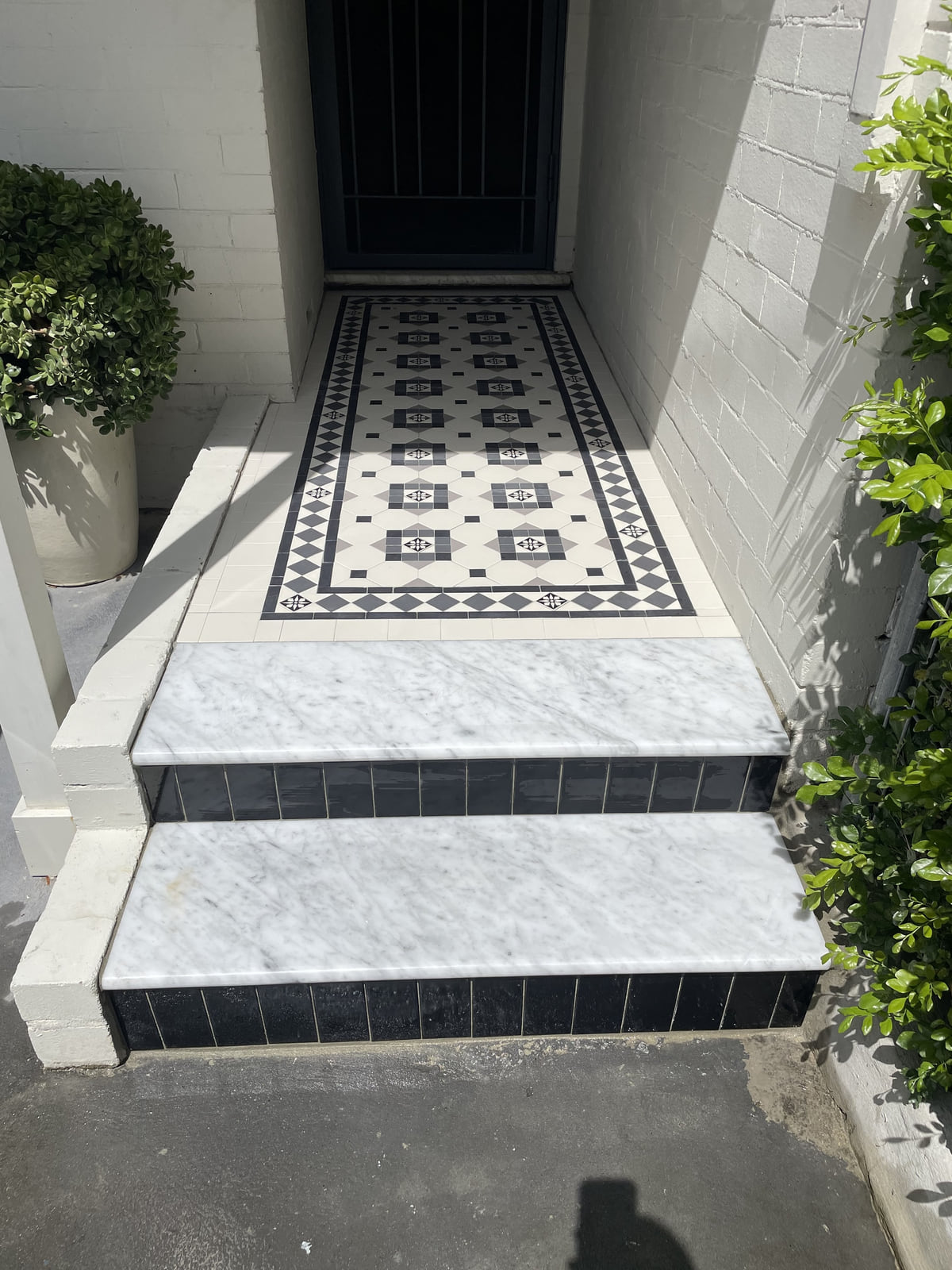 White marble steps with black tiled risers leading up to a Glasgow tiled entry, Drummoyne